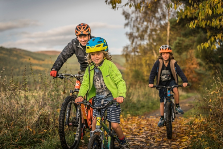 A family of cyclists follow the Deeside country paths. The Cairngorms National Park. The Cairngorm region is a great place for a staycation. Lots of family fun to do including walking, biking and horse riding.